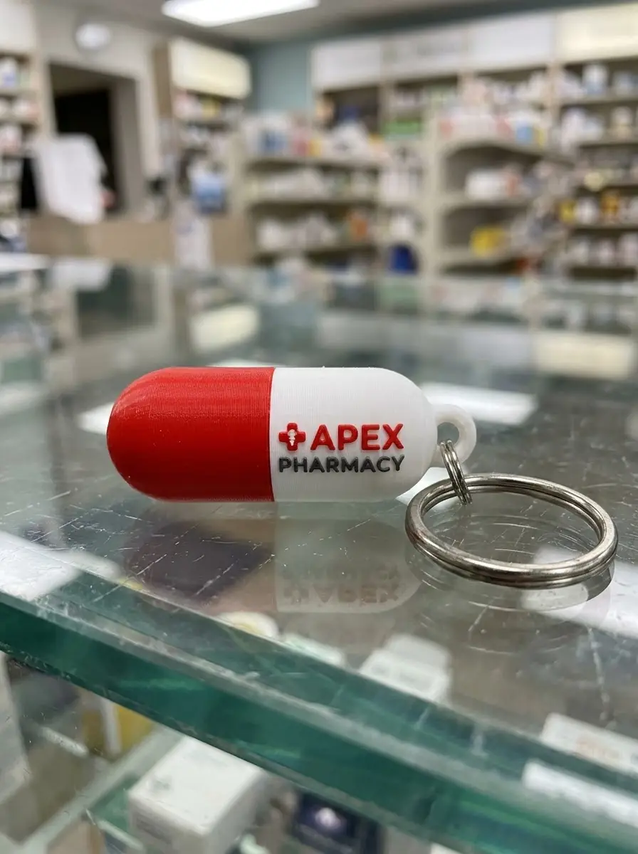 Chaveiro 3D em formato de cápsula com logo de farmácia